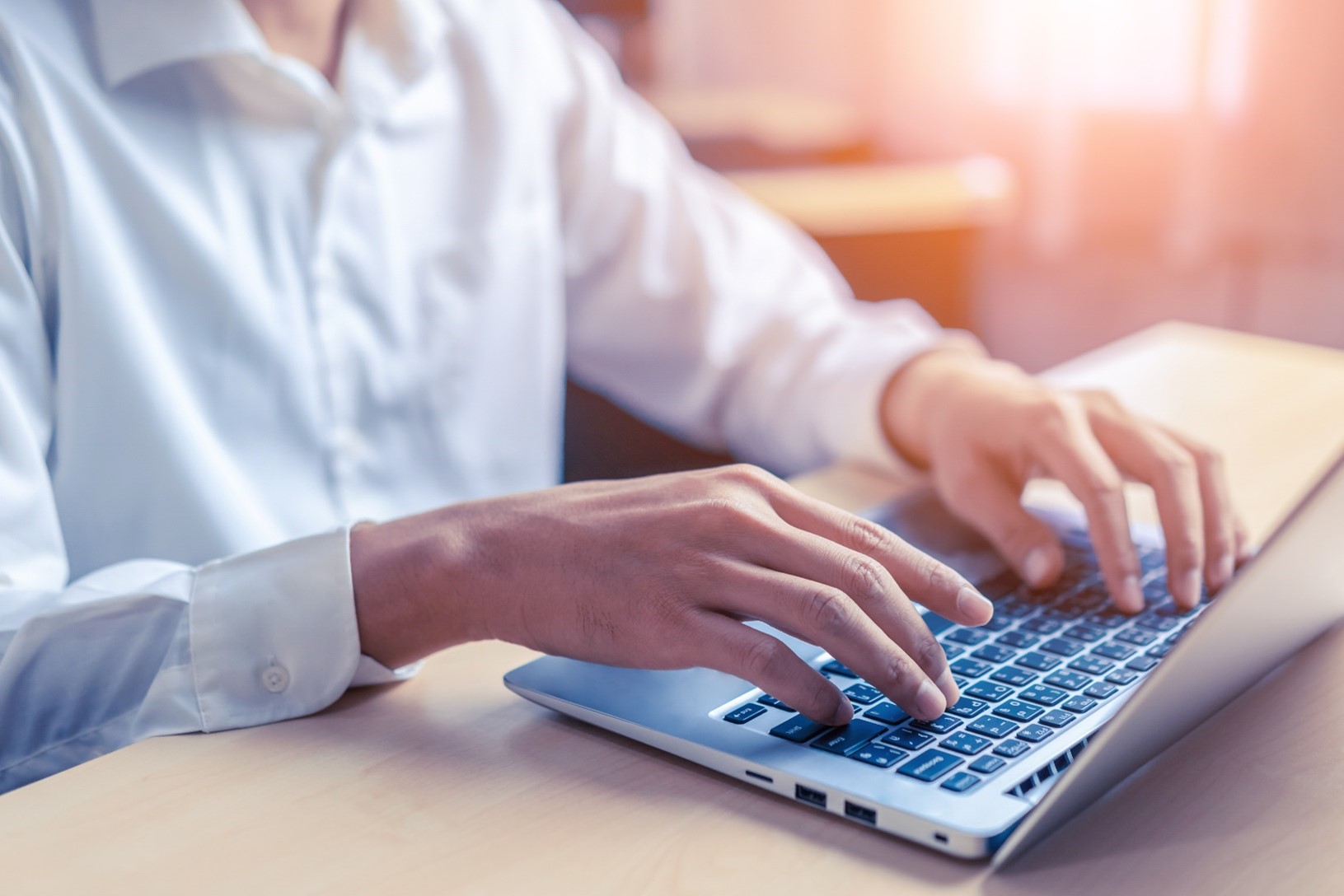 A businessman manually typing data into a computer system