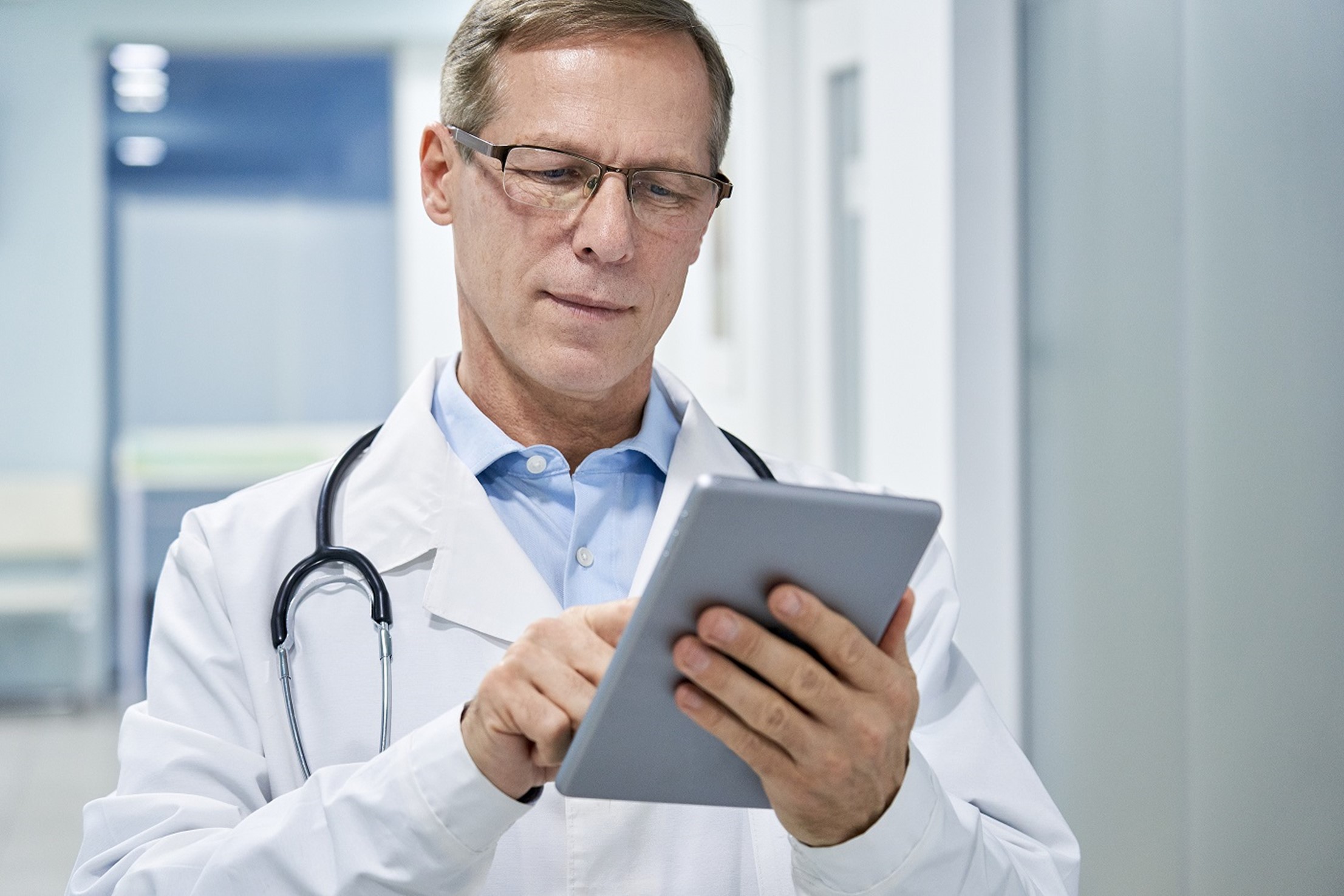 male doctor holding a digital tablet and using industry-specific software technology for medical healthcare