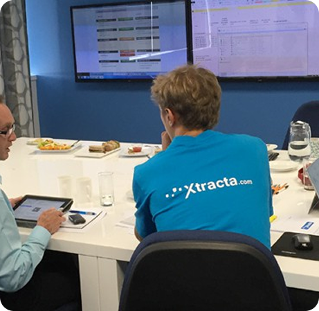 Xtraxta employee in an Xtracta t-shirt sitting at a table with his back to the camera